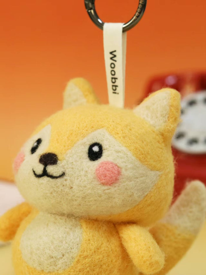 Macro detail of needle-felted fox face showing premium Merino wool texture, rosy pink cheeks, and hand-stitched smile.